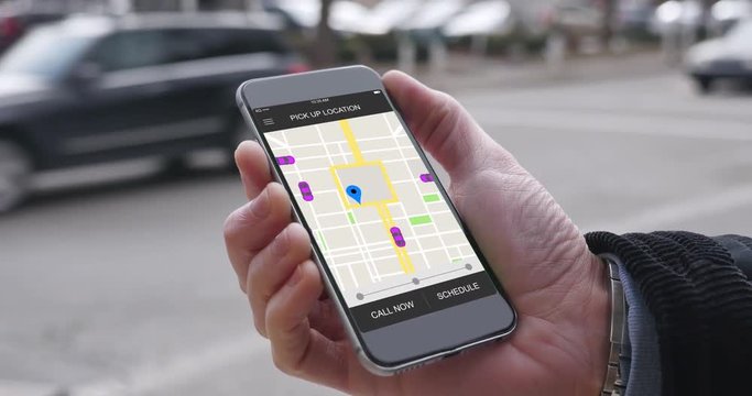 A man uses his smartphone to observe ride sharing traffic patterns on an interactive map in a fictional city.  	