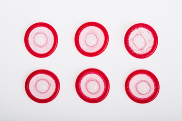 Rolled latex condom on white background