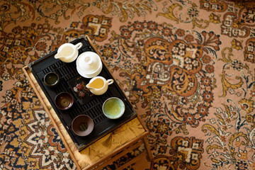 Chinese ceramic cup with green tea on wooden tray. Traditional tea ceremony. Soft focus