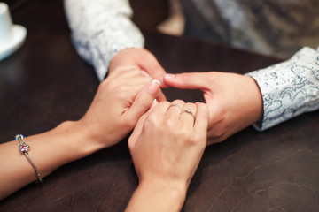 Young couple in love clasping hands across the table