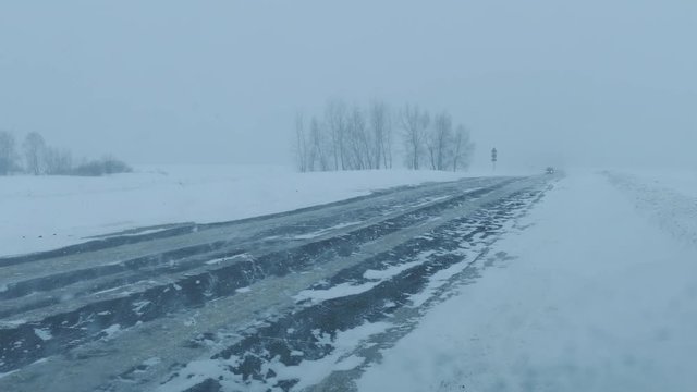 Cars on winter road at blizzard, 4k

