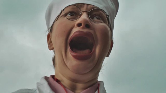 Nurse turn her head and start outcry on summer cloudy day, zoom in