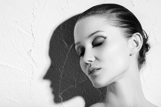 Sensual Female Portrait With Shadow Silhouette On White Wall Background