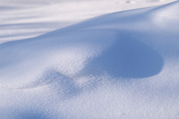 sunlight and shadows on snowdrifts in sunny day