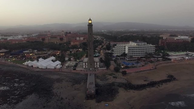 Aerial view of Maspalomas Lighthouse and resort area in the evening. Flying from the coast over the ocean, Gran Canaria