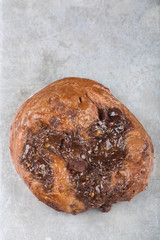 Chocolate custard bun on a baking sheet. Close up. 
