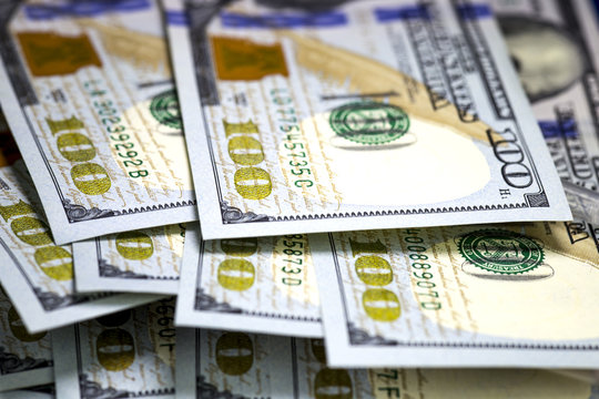 Macro image of US cash money. Hundred US dollar bills. Selective focus. Bills lying on each other.