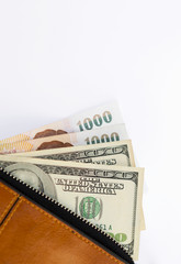 Cash in brown wallet on white background, selective focus