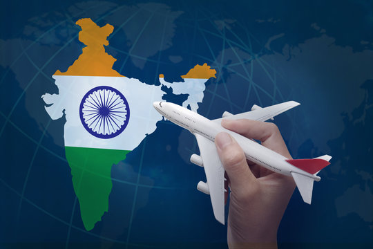 hand holding airplane with map of India.