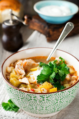 Traditional Russian soup-Rassolnik  wit hpickled cucumber, barley, chicken, tomatoes and parsley in ceramic bowl. Selective focus.