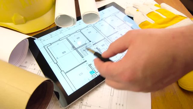 blueprints, tablet and other stuff on table