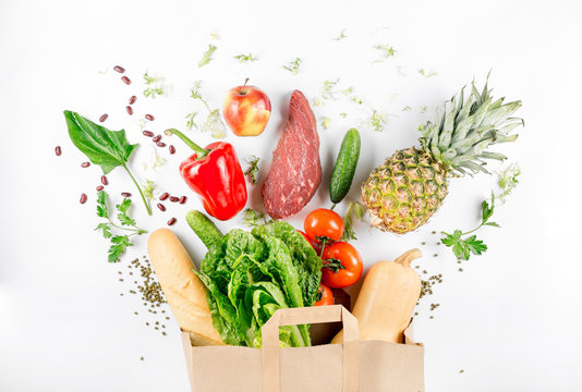 Paper bag full of healthy food on a white background