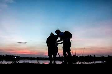 Fototapeta na wymiar Silhouette photographers with sunset background