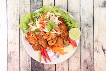 Spicy deep-fried chicken salad with roll green mango .