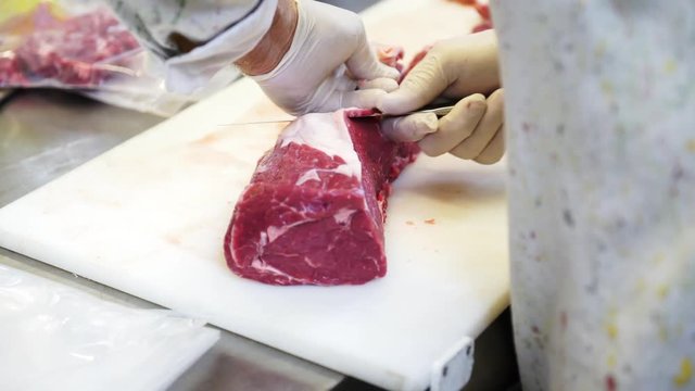 A chef carving the meat for the steaks in his kitchen in Italy, 4K