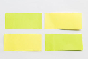 green and yellow post it paper note on white background.