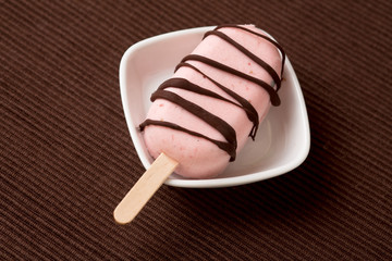 Eis am Stiel mit Erdbeereis und Schokolade als Glasur