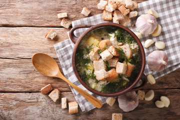 Soup with garlic and croutons close-up in a rustic style. horizontal top view