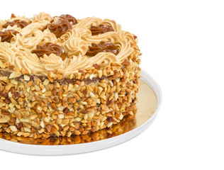Fragment of round sponge cake with butter cream and nuts