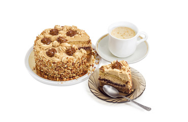 Partly sliced layered sponge cake and coffee with cream