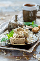 Halva of sunflower seeds and mint on a bronze plate.