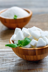 Figured white sugar and mint in a wooden bowl.