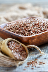 Brown flax seeds in a wooden bowl.