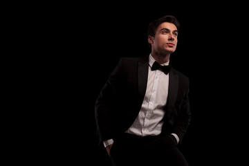 smiling elegant man in tuxedo looking up