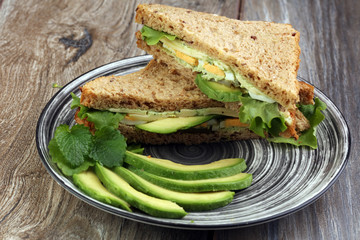 Sandwich with avocado and poached egg - healthy breakfast concep
