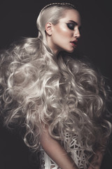 Beautiful girl in art dress with avant-garde hairstyles. Beauty the face. Photos shot in the studio.