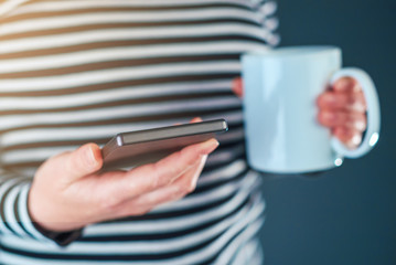 Morning routine, hot coffee and mobile phone messaging