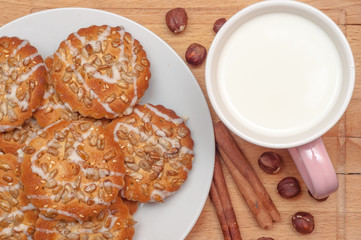 Round cookies with sunflower and sesame seeds, milk in pink mug,