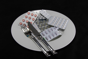 Tabletten auf Teller mit Besteck