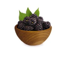 Blackberries on a wooden bowl isolated on white. Ripe blackberry with mint close-up. Background berry. Sweet and juicy blackberry with copy space for text.