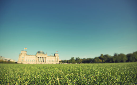 green lawn with the blurred Reichstag building in background, the national german parliament, Berlin, Germany, vintage filtered style 