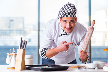 Young man cooking cookies in kitchen