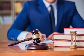 Handsome judge with gavel sitting in courtroom