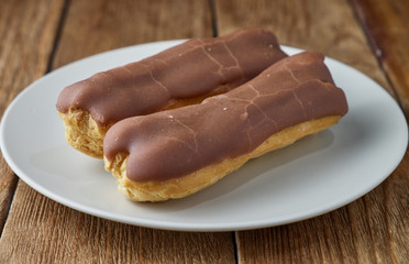 Homemade eclairs with cream and chocolate topping.
