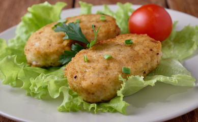 Chicken cutlets with vegetables on a wooden background