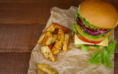 Big burger with fries on wooden