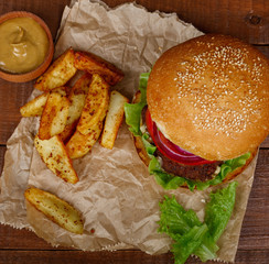 Big burger with fries on wooden