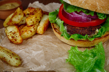 Big burger with fries on wooden