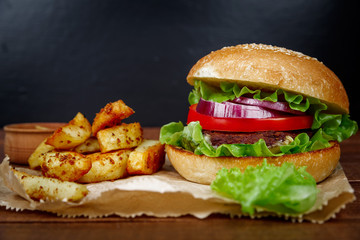 Big burger with fries on wooden