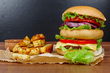 Big burger with fries on wooden