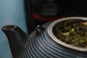 cast-iron tea pot with tea leaves