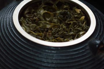 cast-iron tea pot with tea leaves