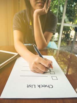 Working woman holding pen and teblet on check list paper and kee