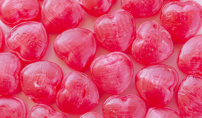 lots of heart-shaped red candy arranged as background for valent