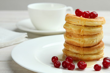 Stack of pancakes with berries on a plate.