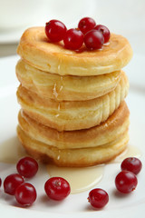 Stack of pancakes with berries on a plate.